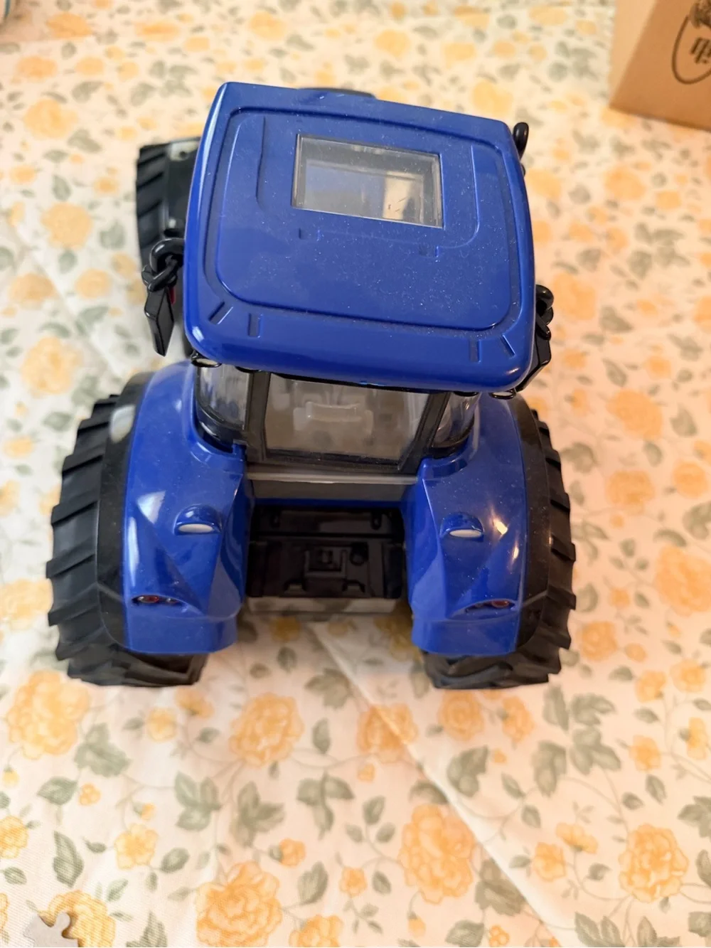 Medium plastic blue and black electronic toy tractor, lights up with sound